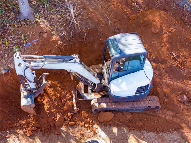 Mini excavator operating on heavy-duty rubber tracks during trenching work
