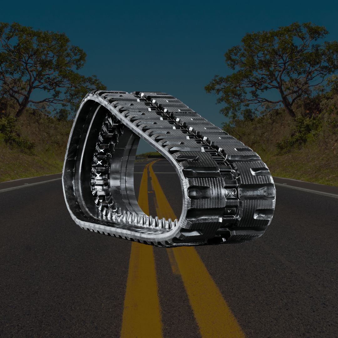 Close-up of a C-Block heavy-duty rubber track floating above a road, showing aggressive lug pattern and steel-reinforced guide system.