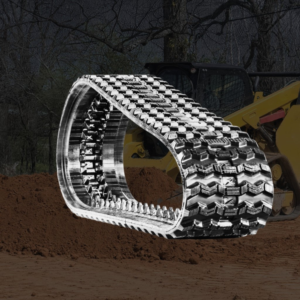 Heavy-duty replacement rubber tracks on a CAT 299D3 track loader working land-clearing terrain.