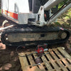 Compact white excavator with black rubber tracks.