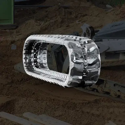Heavy-duty rubber track for a compact track loader (CTL), shown over a CTL machine moving sand and dirt on a job site.