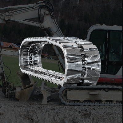 High-performance replacement rubber track for a mini excavator, superimposed over a white mini excavator working on a gravel construction site.