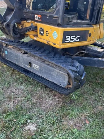 John Deere 35G mini excavator with TrackTECH tracks — side undercarriage/blade view.