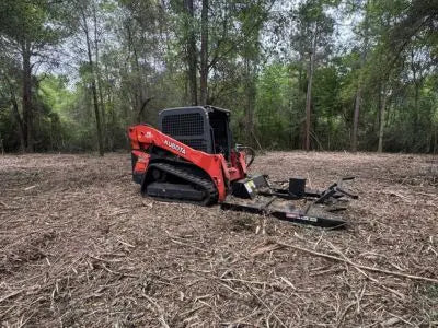 Kubota SVL75-2 compact track loader operating on rubber tracks in wooded terrain