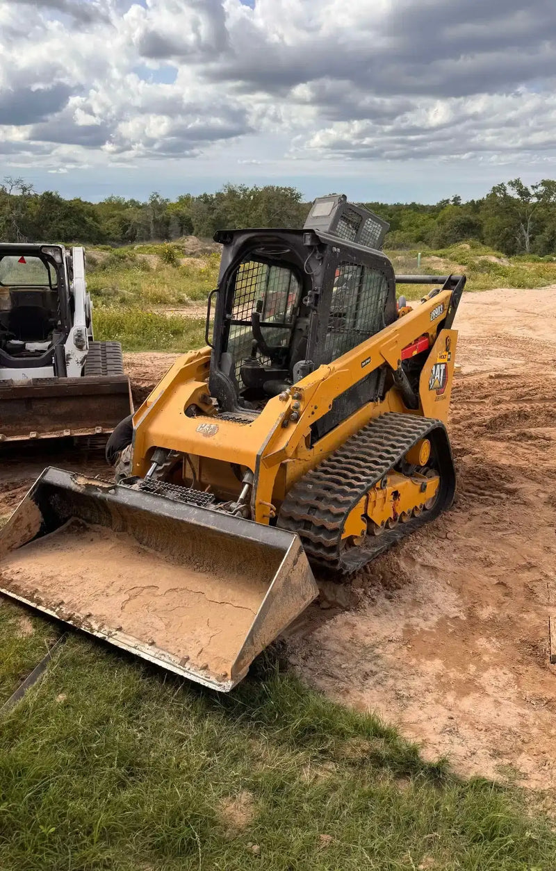 Compact track loader with heavy-duty rubber tracks operating on a dirt jobsite.