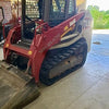 Red and white Takeuchi compact track loader with a front bucket.