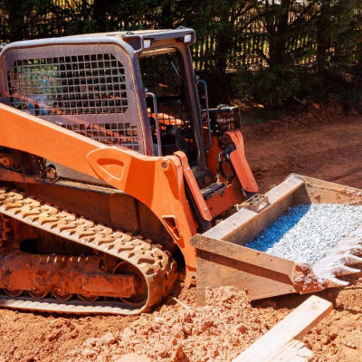Skid steer on rubber tracks loading gravel — TrackTECH rubber tracks